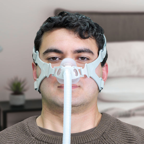 Man wearing a CPAP mask in a bedroom setting