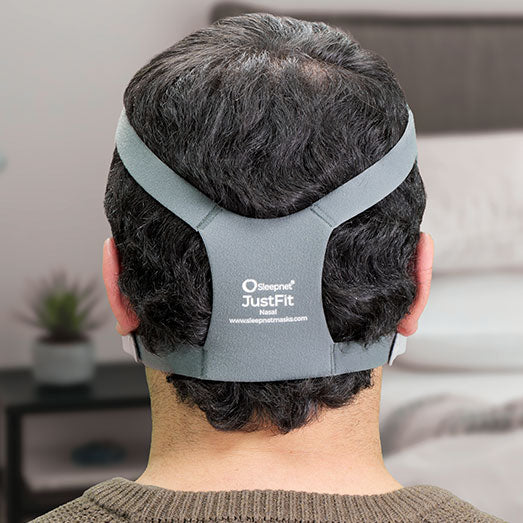 Person wearing a gray headgear in a neutral indoor setting