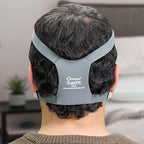 Person wearing a gray headgear in a neutral indoor setting
