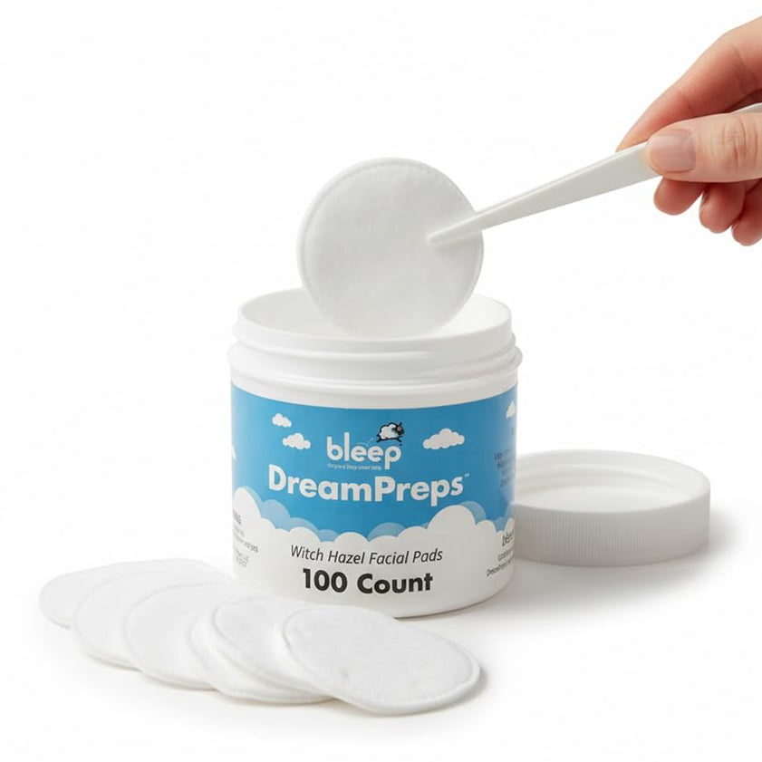 Container of bleep DreamPreps Witch Hazel Facial Pads with a hand using a scoop to take out pads.