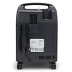 Back view of a black portable oxygen concentrator with visible branding on a white background