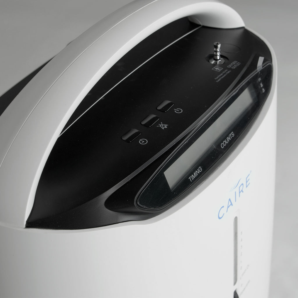 Close-up of a Caire oxygen concentrator with control panel and brand name.