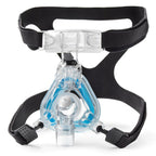 Clear CPAP mask with black straps on a white background