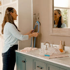 Woman using a CPAP Soap hose tubing hanger in a bathroom 