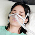 Woman using a CPAP mask to sleep, with coaphero mouth tape  