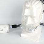 ResMed CPAP device on a mannequin head with a white background