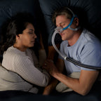 Man in bed sleeping with a Nova CPAP Mask on 