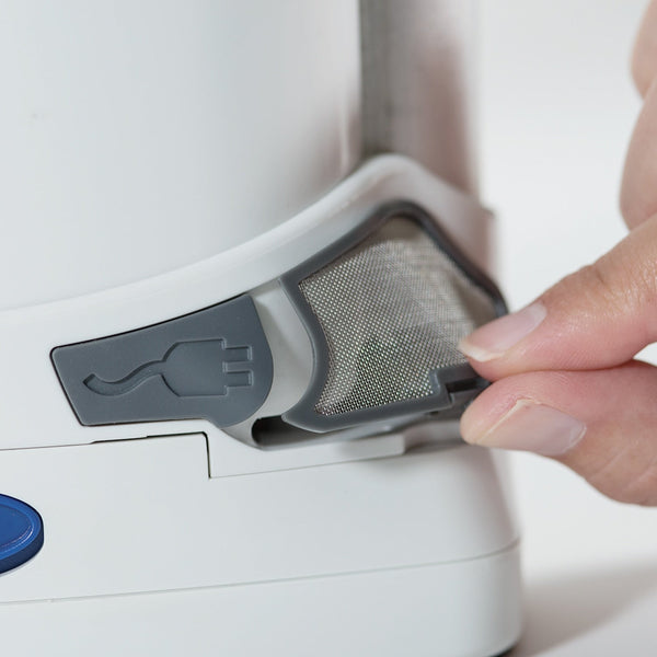 Person removing a filter from a freestyle oxygen concentrator with a gray mesh component.