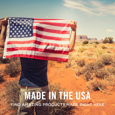 Person holding an American flag in a desert landscape with text 'Made in the USA'.