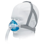 CPAP mask with blue cushion on a mannequin head against a white background