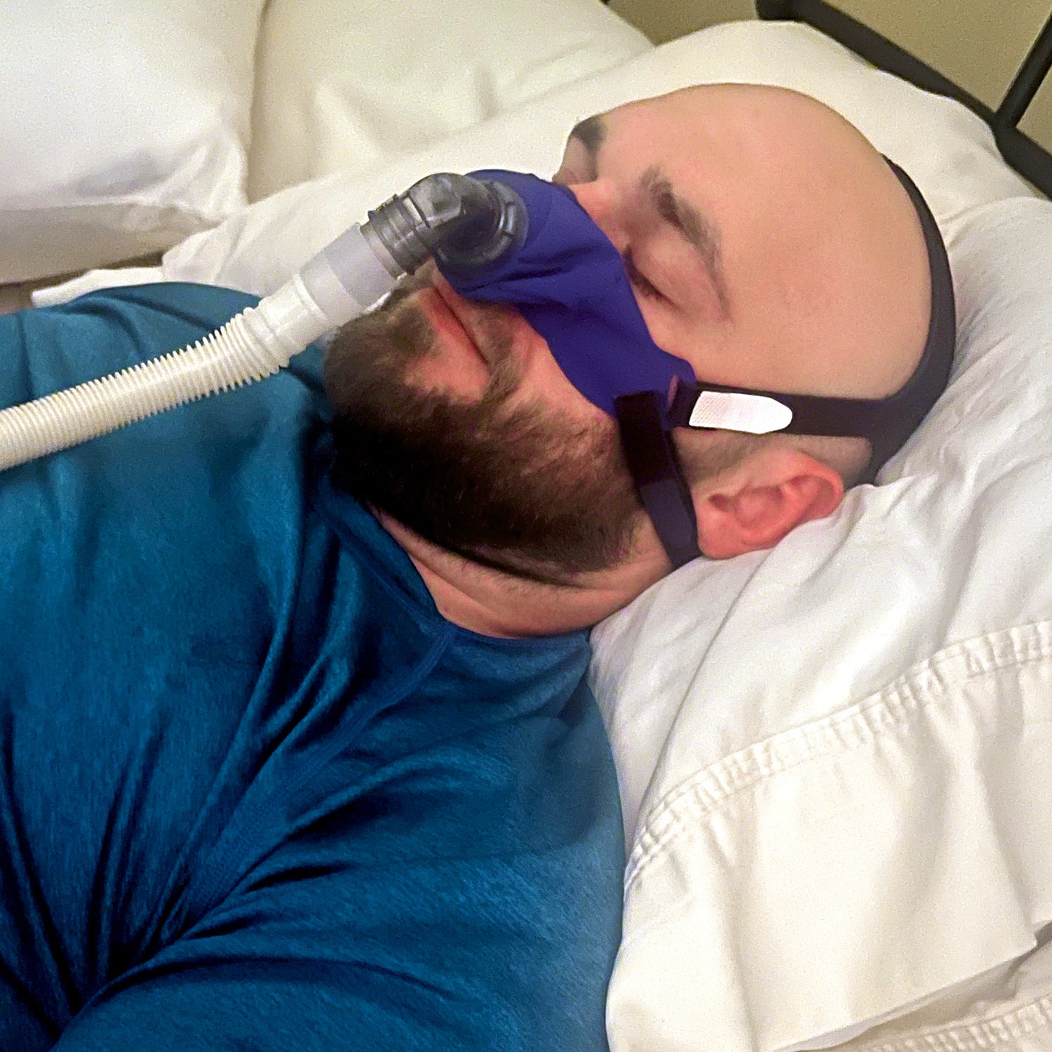Person using a CPAP machine while sleeping in bed