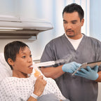 Woman using a Misty fast small volume nebulizer in a hospital setting next to a male doctor 