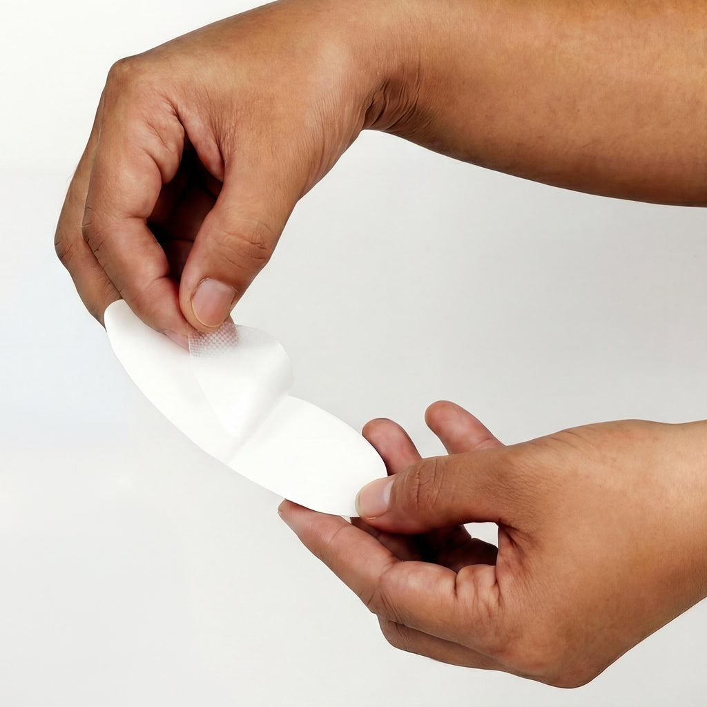 Hands holding a mouth strip against a plain background