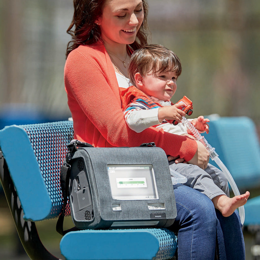 Lady on bench with child and Trilogy Evo in use 
