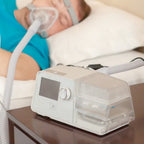 react health Luna G3 BIPAP machine on a nightstand with a person using it in the background