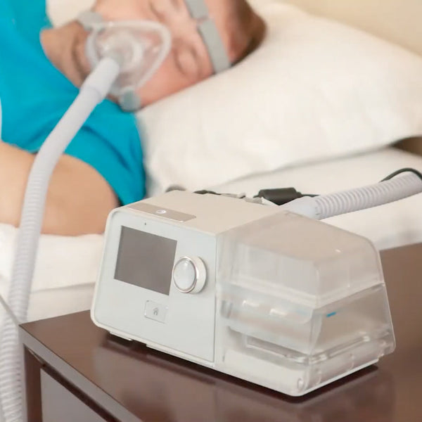 react health Luna G3 BIPAP machine on a nightstand with a person using it in the background