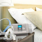resmed aircurve 10 bilevel machine and cpap mask on a nightstand next to a bed
