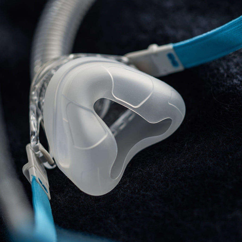Close-up of a rollout nasal CPAP mask on a dark background