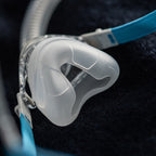 Close-up of a rollout nasal CPAP mask on a dark background