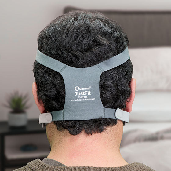 Person wearing a Sleepnet JustFit full face mask in a bedroom setting