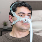 Man wearing a CPAP mask with a hose in a room setting