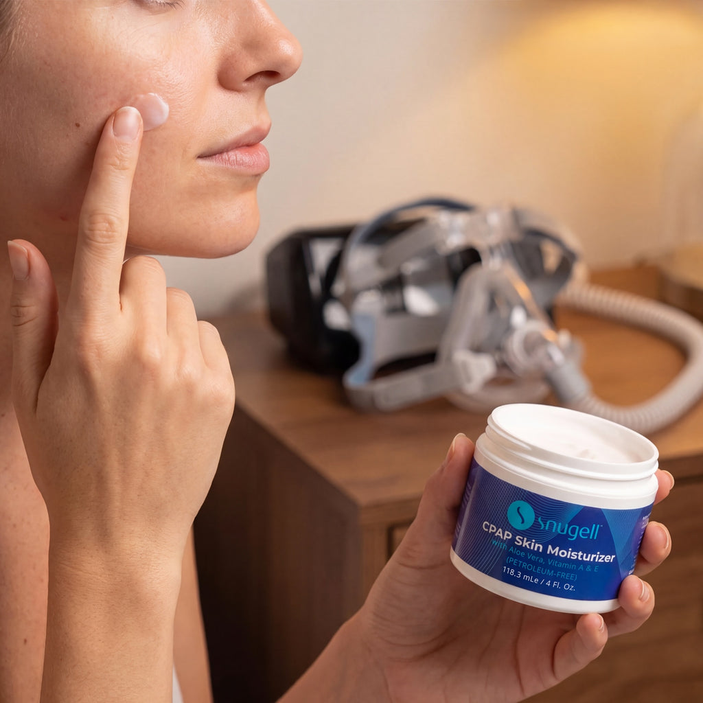 Person applying Snuggell CPAP Skin Moisturizer to their face with a CPAP machine in the background.