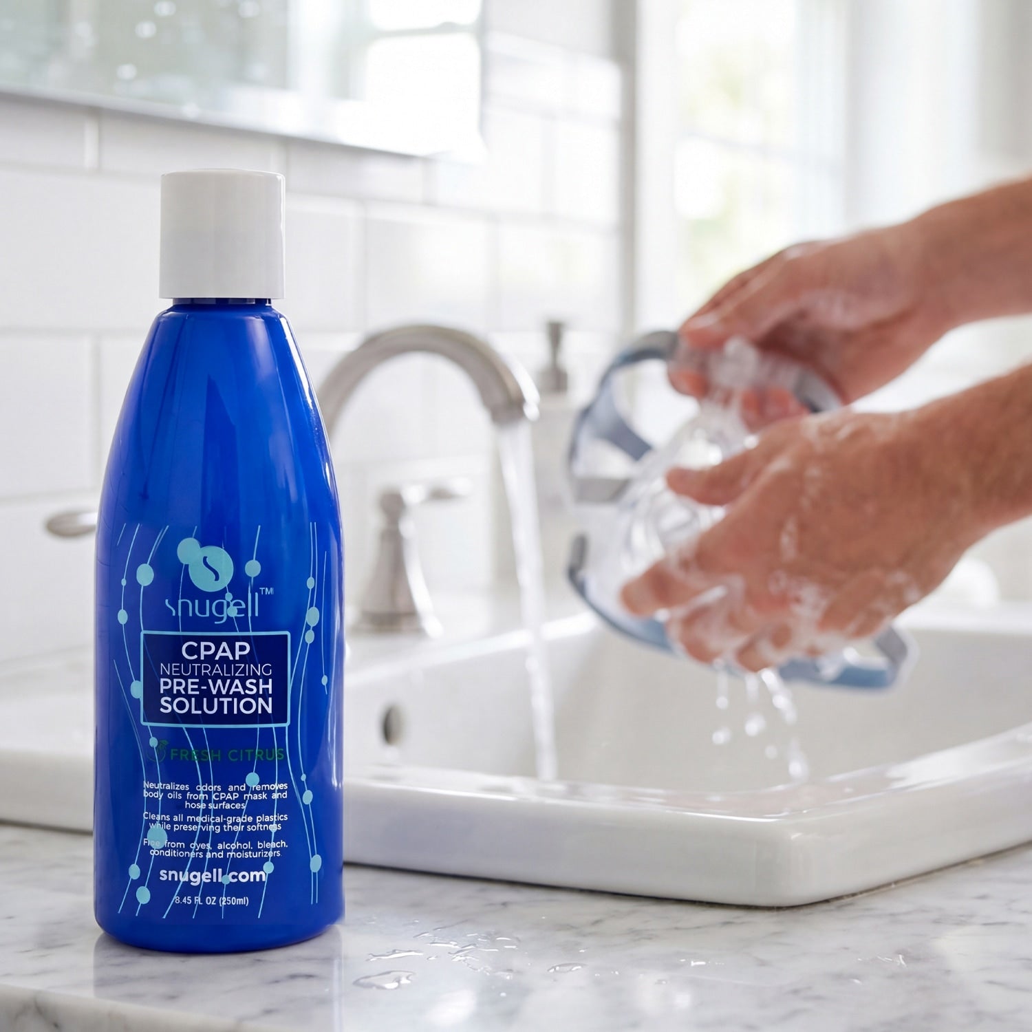 Person holding a clear plastic device with soap suds, next to a blue bottle on a white surface.