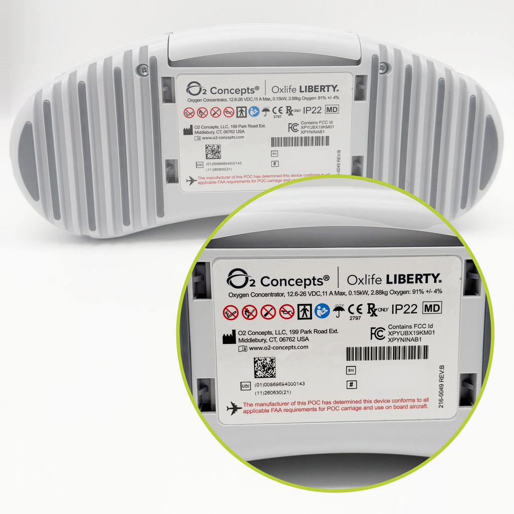 A white ribbed cylindrical device shown from the back with a circular inset zooming in at the bottom right on the printed label. The label reads O2 Concepts | Oxify LIBERTY' and includes regulatory marks and barcodes.