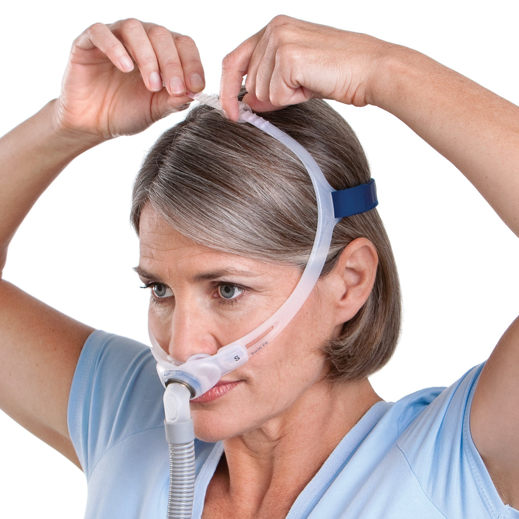 Woman adjusting a CPAP mask on her face against a white background