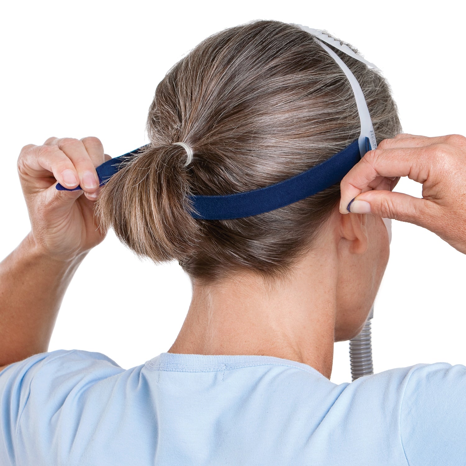 Person adjusting a blue headgear with a white background