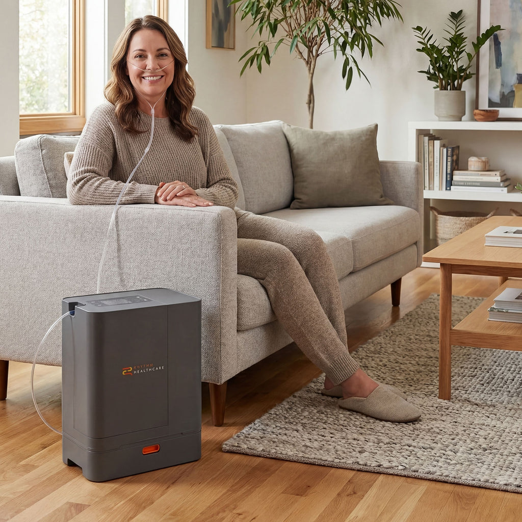 Woman sitting on a couch next to a TOC 3 Oxygen Concentrator in a living room.