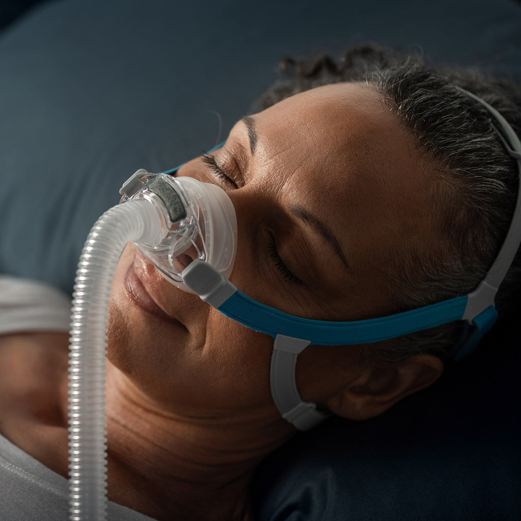 Person using a CPAP mask with a dark background